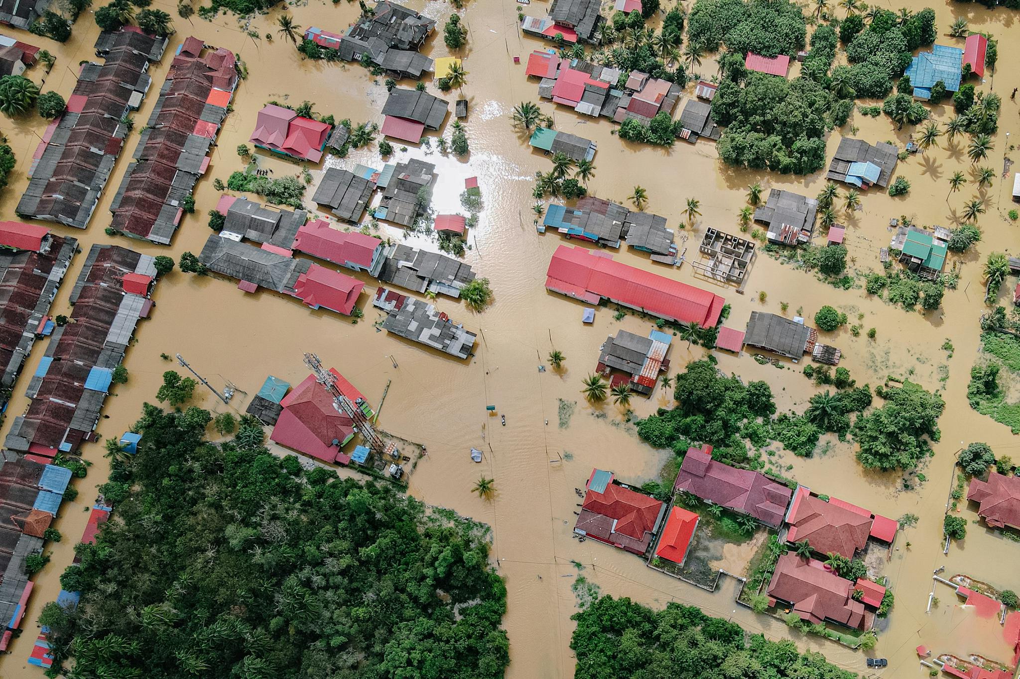 Aerial shot showing a residential neighborhood submerged in floodwater after torrential rains.
